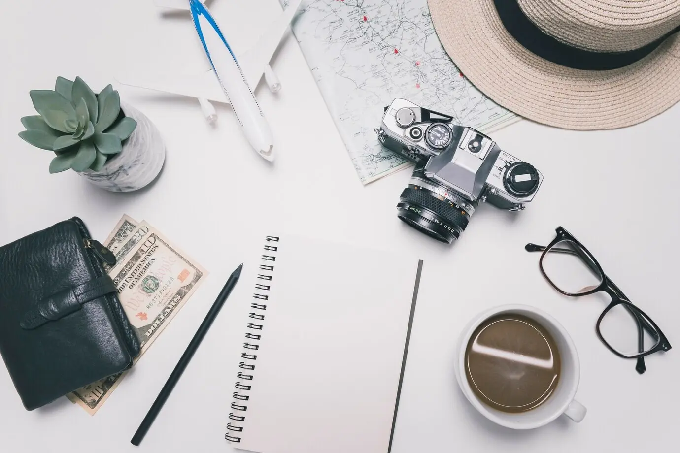 Leeres Notizbuch neben Reiseutensilien.